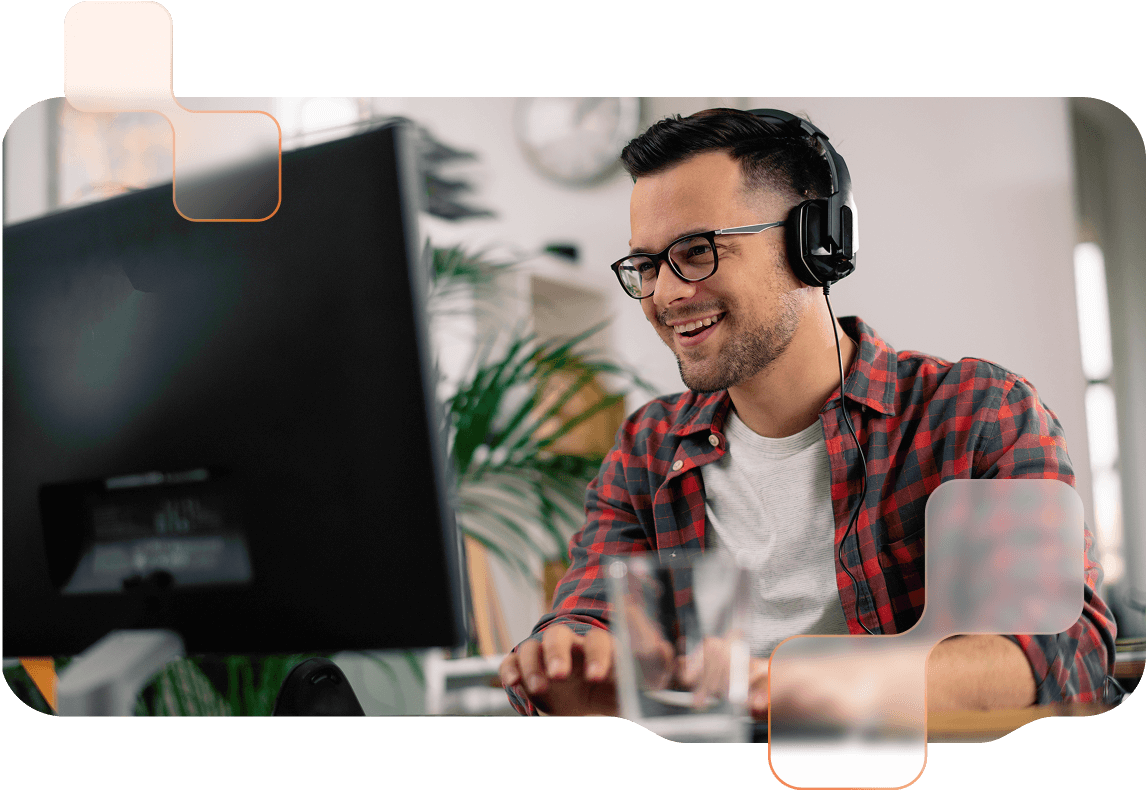 Teaser-BMD-Akademie Mann mit Brille sitzt mit Headset vor einem Desktop und lächelt.