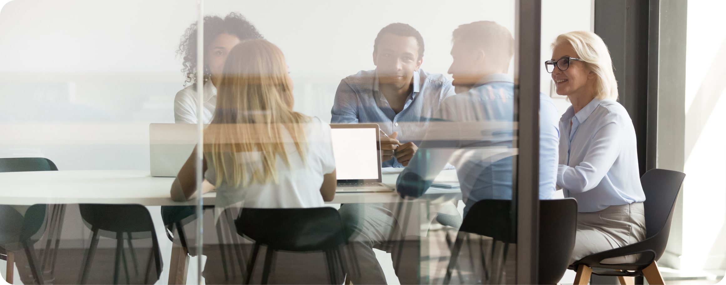 Header Software für die Wirtschaftsprüfung Männer und Frauen sitzen für ein Meeting am Tisch.