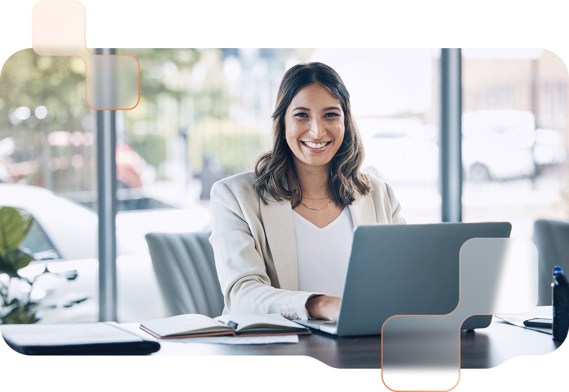 Zusammenarbeit-Steuerberater-BMD Eine Frau mit braunen Haaren sitzt am Laptop und lächelt in die Kamera.