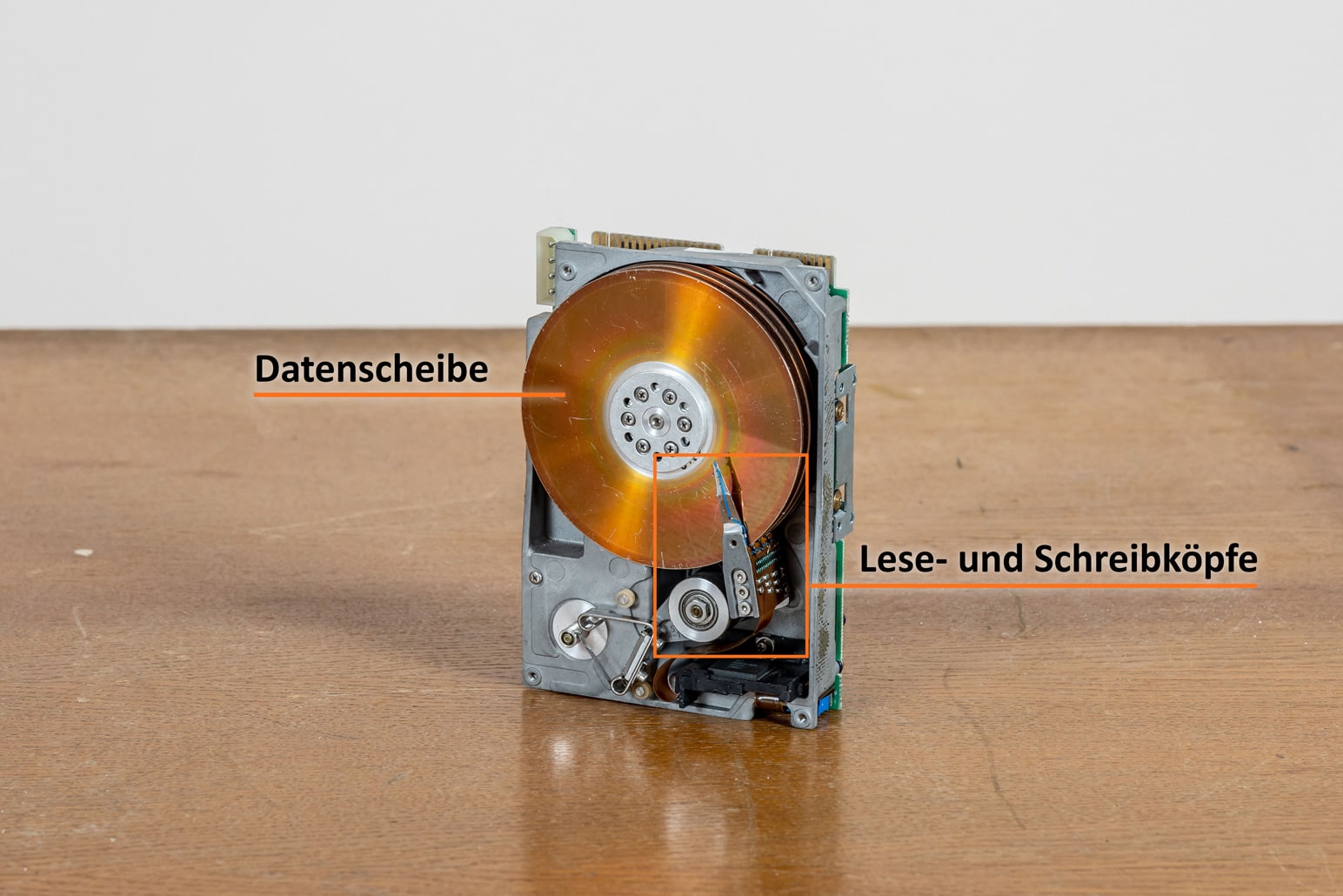 Festplatte mit Lese- und Schreibköpfen auf Holztisch
