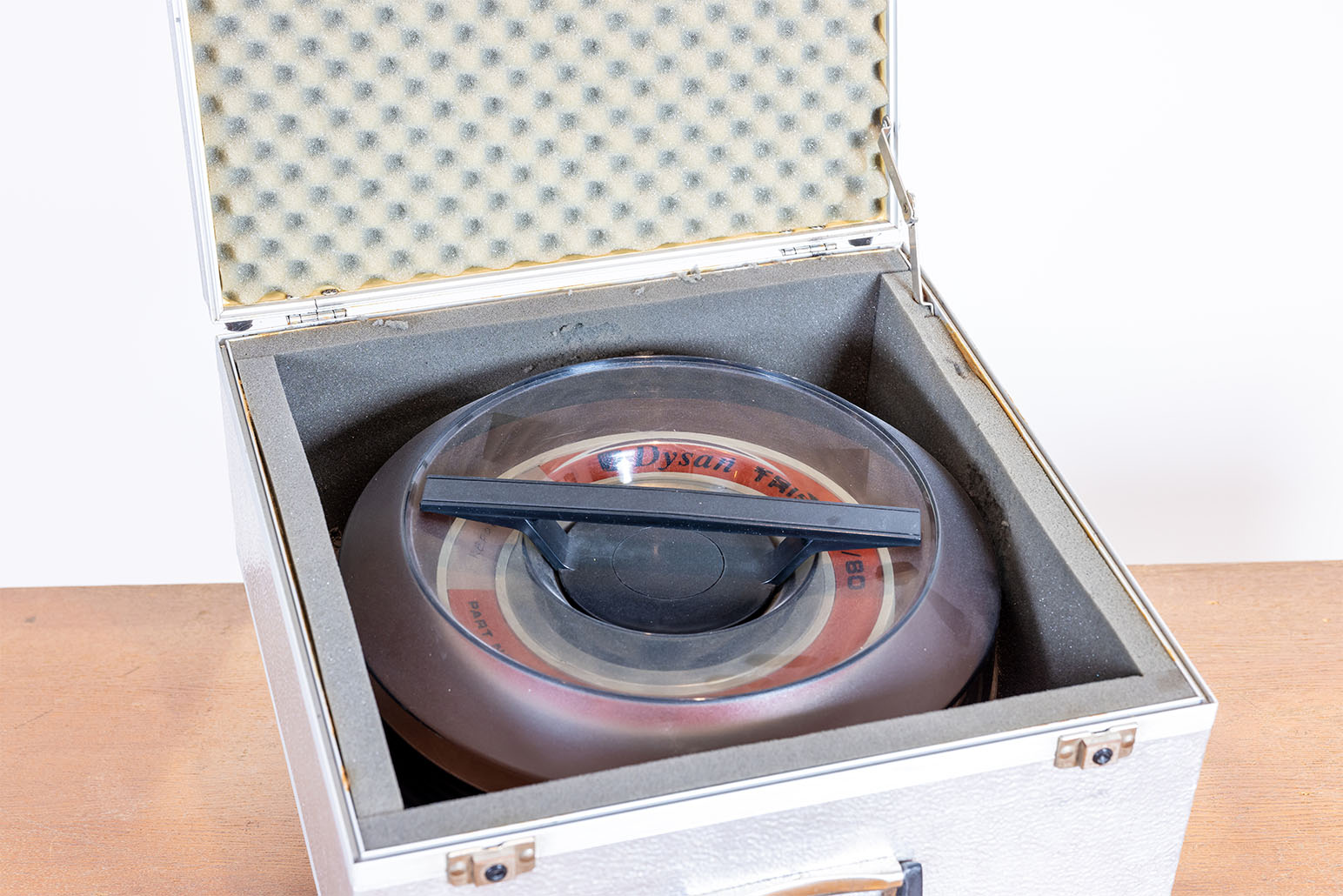 Runde Festplatte in silbernem Transportkoffer auf Holztisch