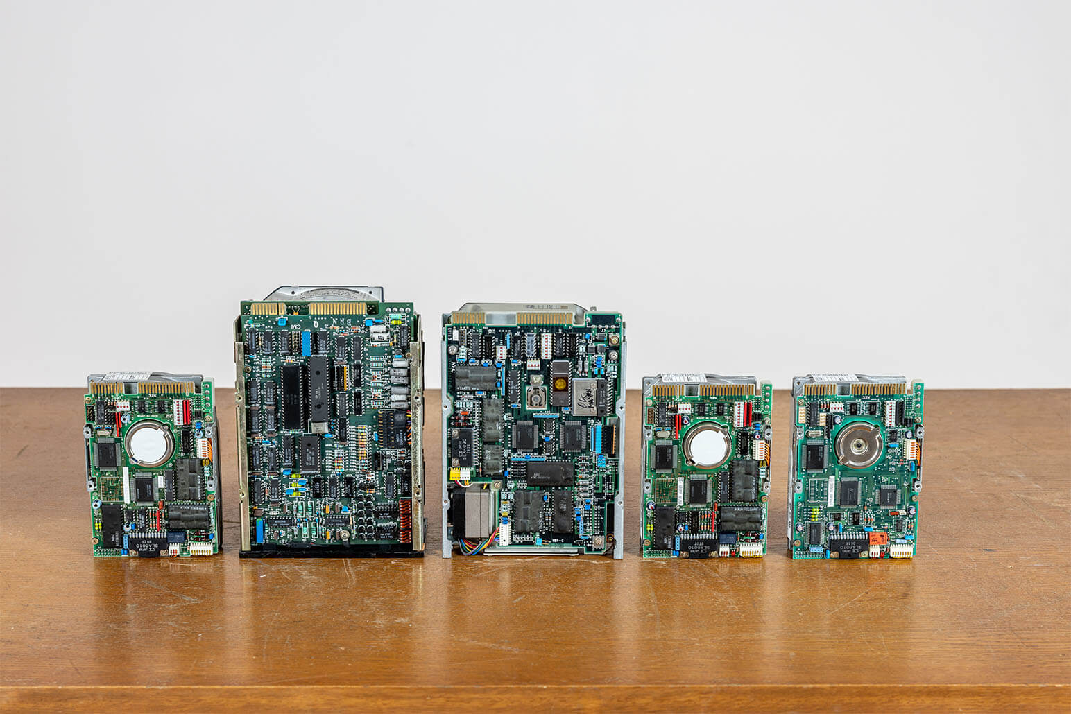 Fünf Festplatten auf Holztisch nebeneinander aufgestellt