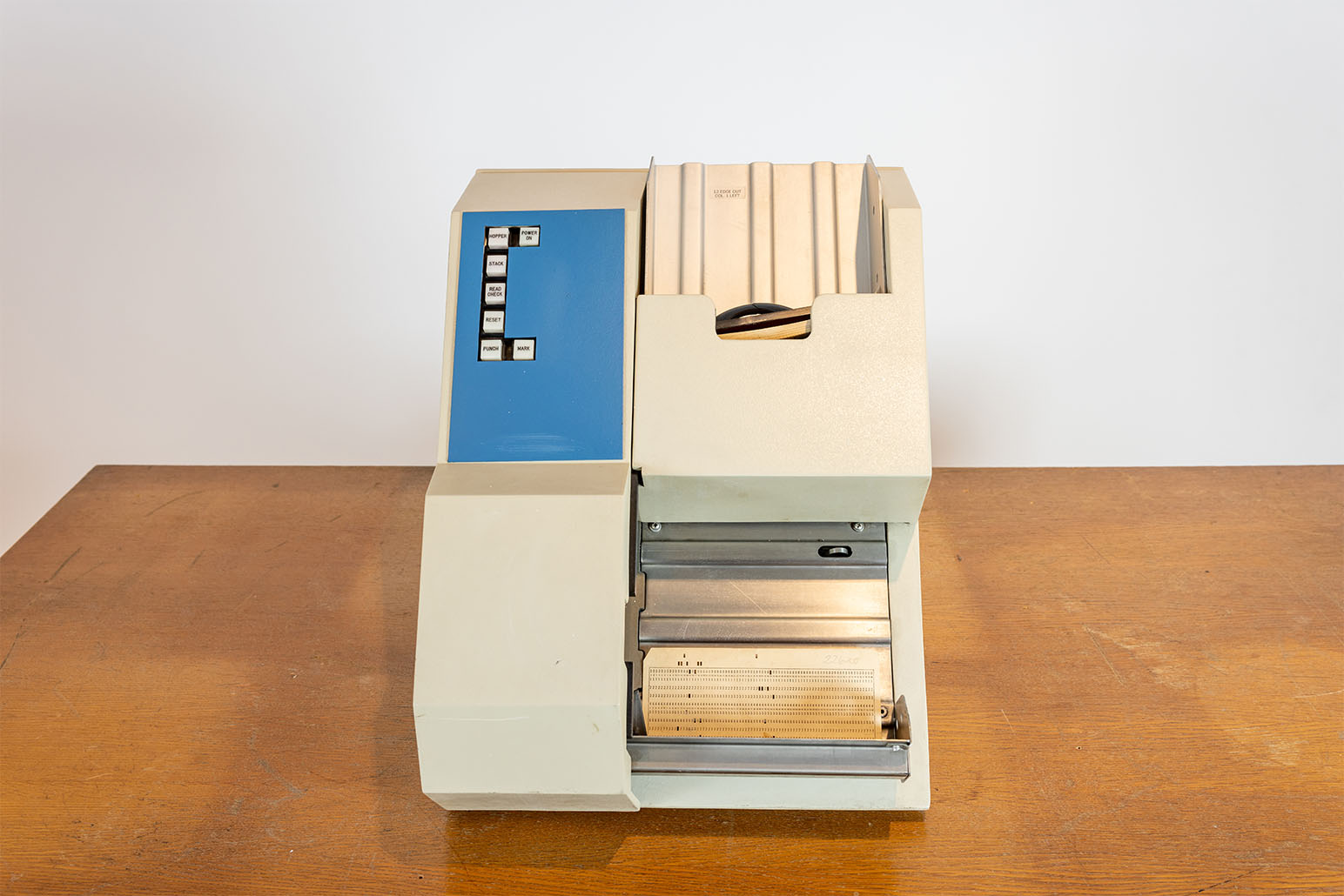 Beiger Lochkartenleser mit blauem Element vor weißer Wand