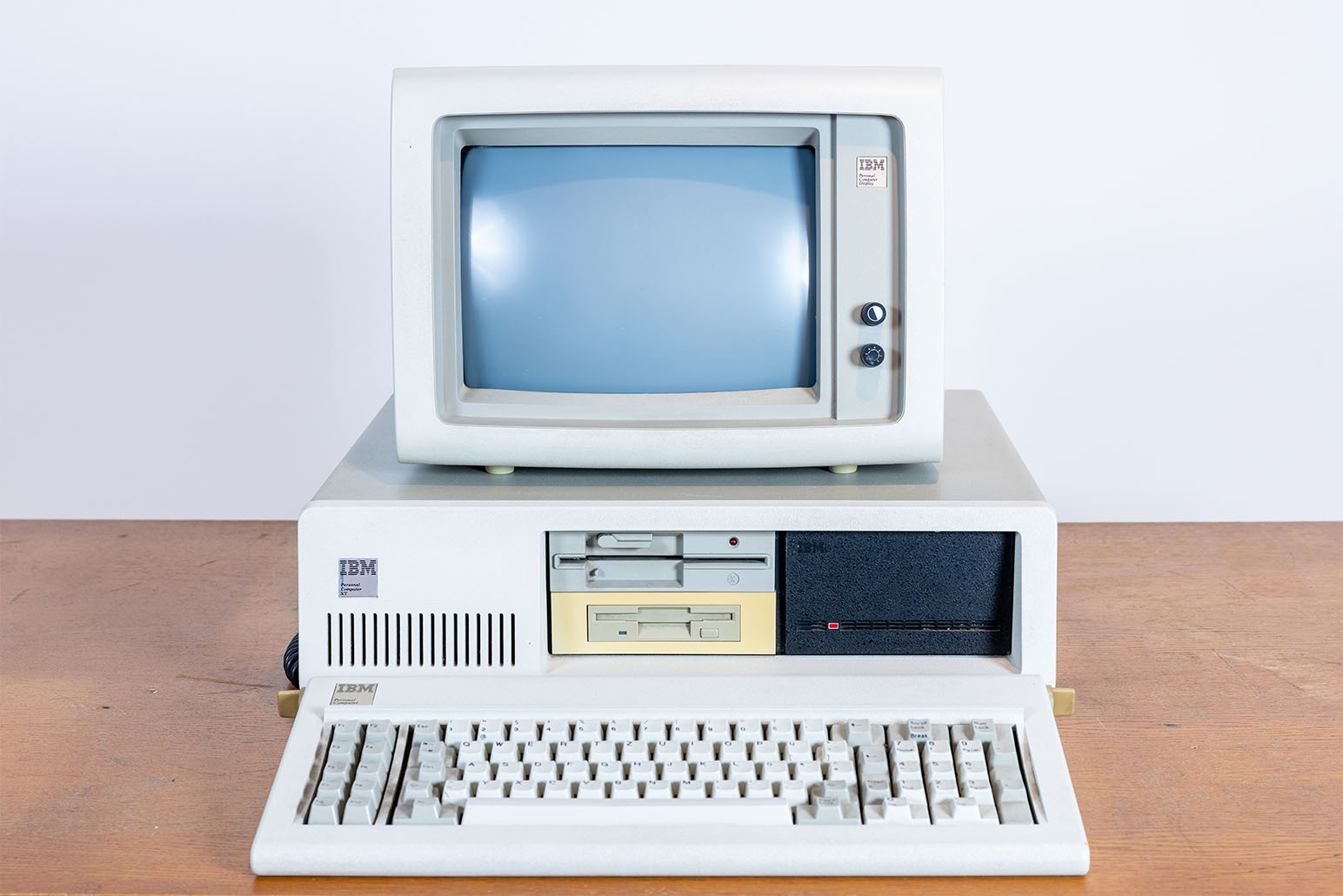 Weiß-grauer PC mit Bildschirm und Tastatur auf Holztisch