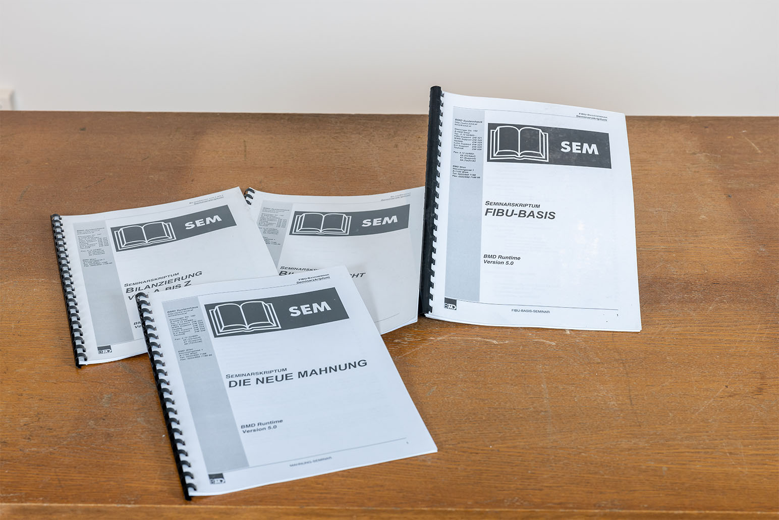 Vier Seminarskripten liegen auf Holztisch