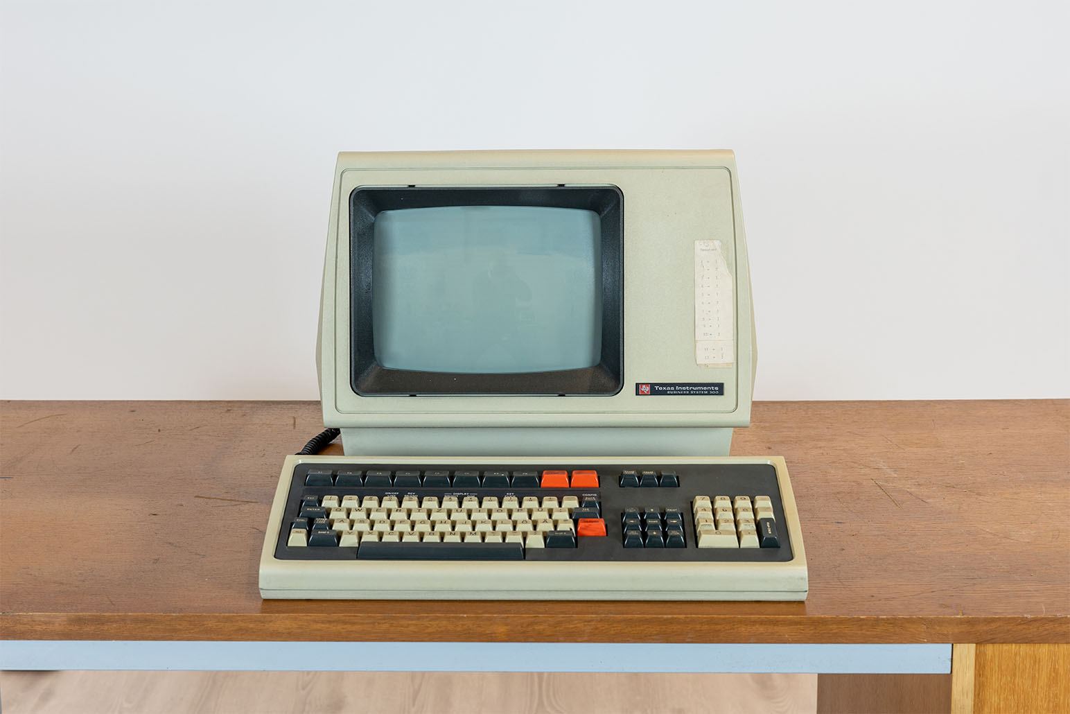 Beiger PC mit beige-grauer Tastatur auf Holztisch