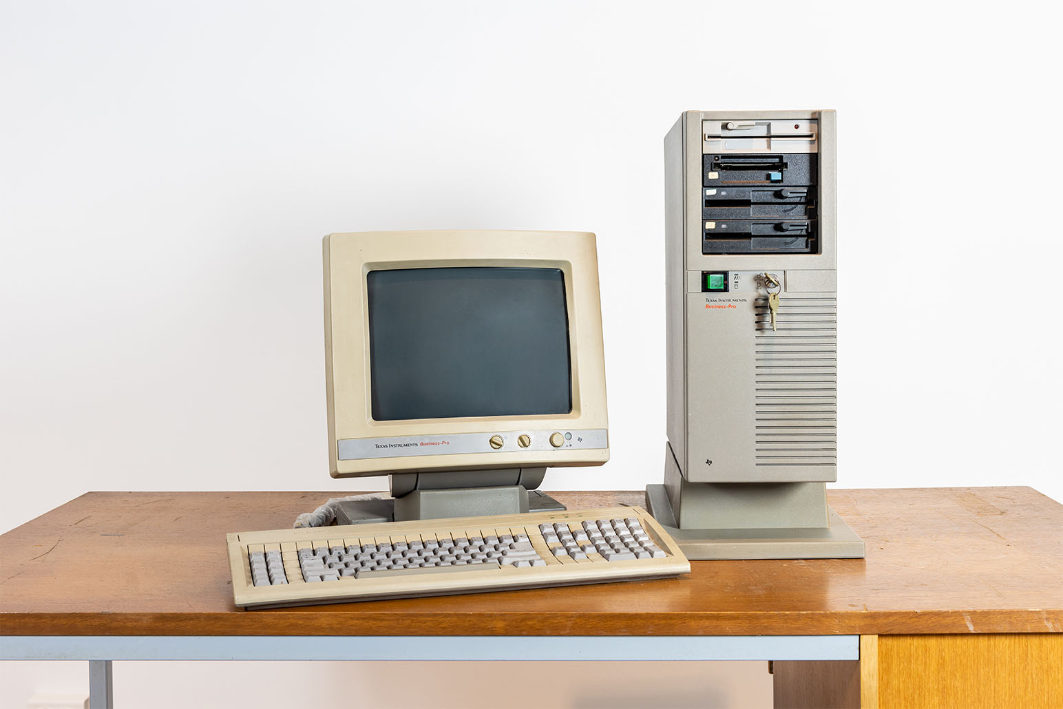 Grau-beiger Bildschirm & Tastur und grauer PC auf Holztisch