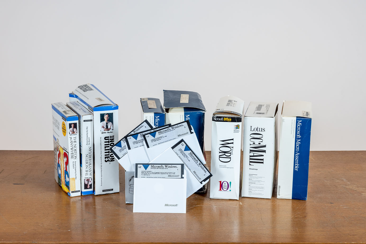 Disketten, Anleitungen und Verpackungen der Microsoft Software auf Holztisch