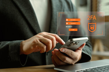 Person tippt auf Smartphone. Einblendung zur 2 Faktor Authentifizierung sichtbar. 