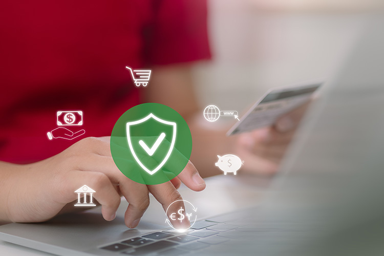 Bild zeigt die Hand einer Frau die auf dem Laptop etwas tippt, in der Hand hält sie eine Bankomatkarte