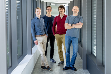 4 BMD Mitarbeiter (Team AI & Data Science) stehen in einem Gang des BMD Gebäudes und lächeln in die Kamera.