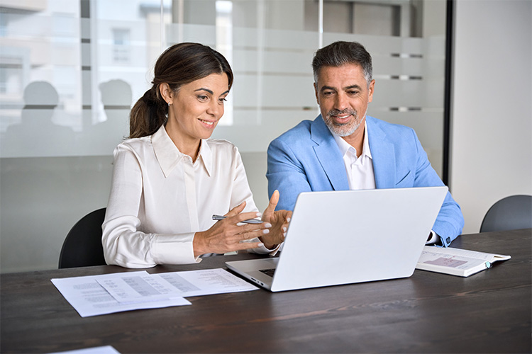 Ein Mann und eine Frau die am Notebook sitzen