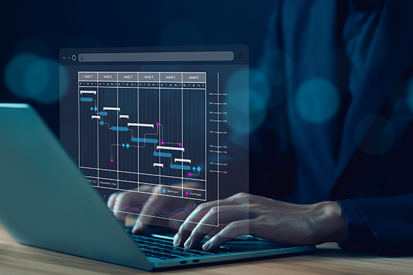Egy nőt látsz, aki egy laptopon gépel, az előtérben egy grafika jelenik meg.