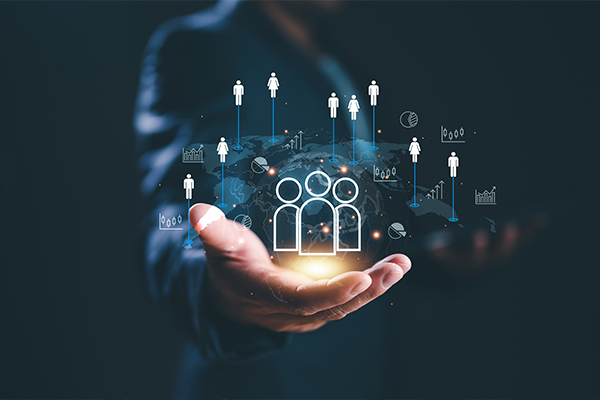 Egy férfi nyitva tartja a kezét, amelyben különböző ivonok lebegnek, középen egy ikon, amely 3 embert ábrázol.