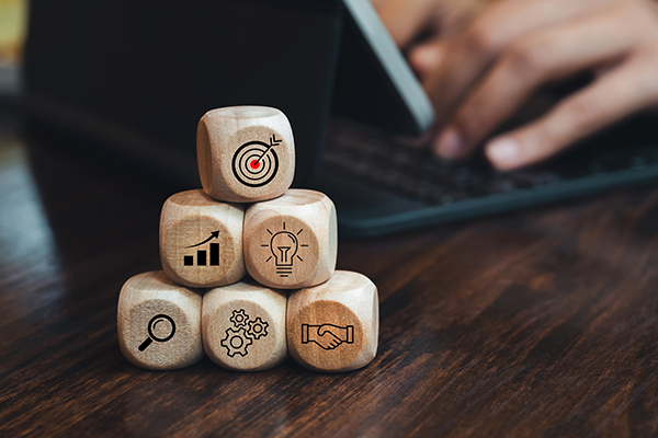 A képen 6 fakocka látható piramis alakban egymásra rakva. Minden kockán egy szimbólum látható.