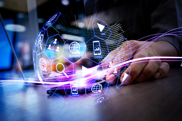 Egy férfi kezében egy okostelefont és egy laptopot tart, előtte egy labdarúgó alakú ikonok lebegnek a levegőben.