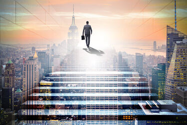 Vidíme muža s kufríkom, ktorý stúpa po schodoch a v pozadí je veľké mesto.